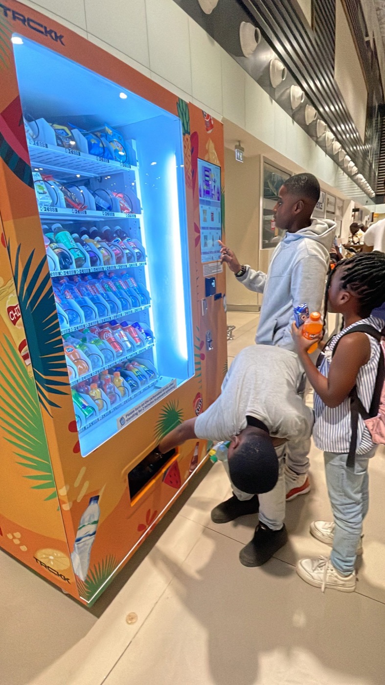 Children buying drinks from a Swaggers machine